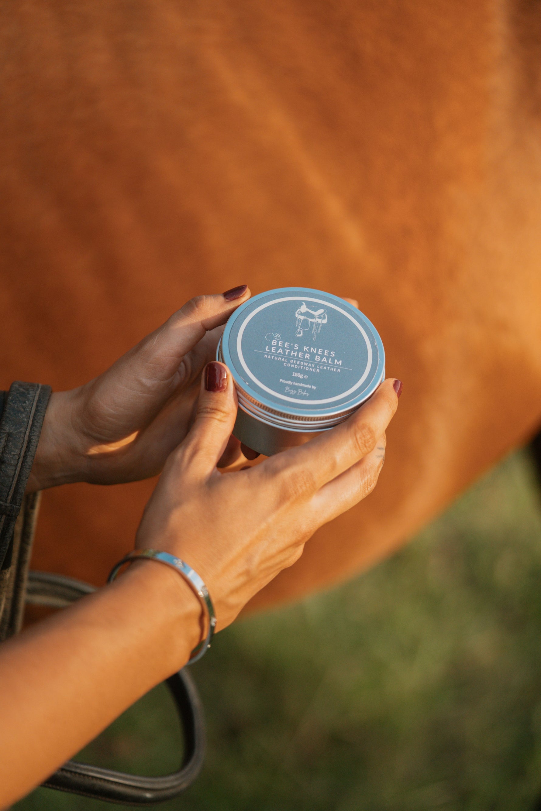 Person holding Buzz Balms Bees Knee's Leather Balm